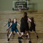 Sorrell-Howard Hall of Fame Honor for Booneville Native Women's basketball players in action near the hoop on an indoor court, illustrating the Sorrell-Howard Hall of Fame induction