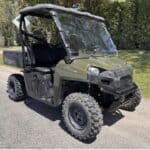 Crime Stoppers asks for tips on stolen Polaris Ranger in Prentiss County A green Polaris Ranger utility vehicle parked outdoors on a paved road beside grass and trees.