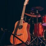 Crossroads Arena Hosts Mark Chesnutt, Pam Tillis Tonight Acoustic guitar and drums on a lit stage, illustrating the Crossroads Arena concert in Corinth