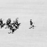 Alcorn Central Band Takes 2nd at Crossroads Marching Classic Marching band led by a drum major across a grass field, illustrating the Crossroads Marching Classic