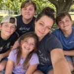 Jessica Anderson’s NEMCC Adult Education path leads to college A woman takes a selfie with four children seated closely together outdoors under a tree.