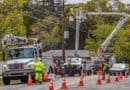 ACE Power Crew Heads to Alabama to Help After Isaias Utility line workers in bucket trucks repair overhead power lines on a residential street, illustrating an ACE Power crew on storm duty