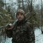 The 5 Best Two-Way Radios for Alcorn County Hunting Camps Deer hunter in camouflage walking through the woods at hunting camp