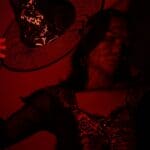 The 5 Best Halloween Costumes for Alcorn County Grown-Ups A woman dressed in a witch costume under dramatic red lighting
