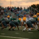 Area High School Football Scores: Corinth, Booneville Win High school football teams line up at sunset, illustrating area high school football scores
