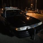 Baldwyn Police Warn Yard Rolling Pranks Can Bring Charges Police car parked on a quiet residential street at night, illustrating the Baldwyn police yard rolling warning