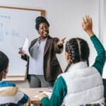 Booneville Schools Earn B Rating; High School Gets an A Teacher answering a student's question in a classroom, illustrating the Booneville school rating