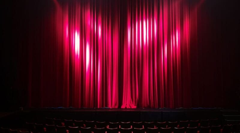 Empty theater stage with red curtains, illustrating the Corinth Dramatic Society playhouse lease