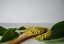Corinth Kratom Ban Takes Effect Immediately Herbal powder on a wooden spoon with green leaves, illustrating products covered by the Corinth kratom ban
