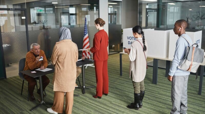 Voters waiting in line at a polling place, illustrating the Corinth mayor election