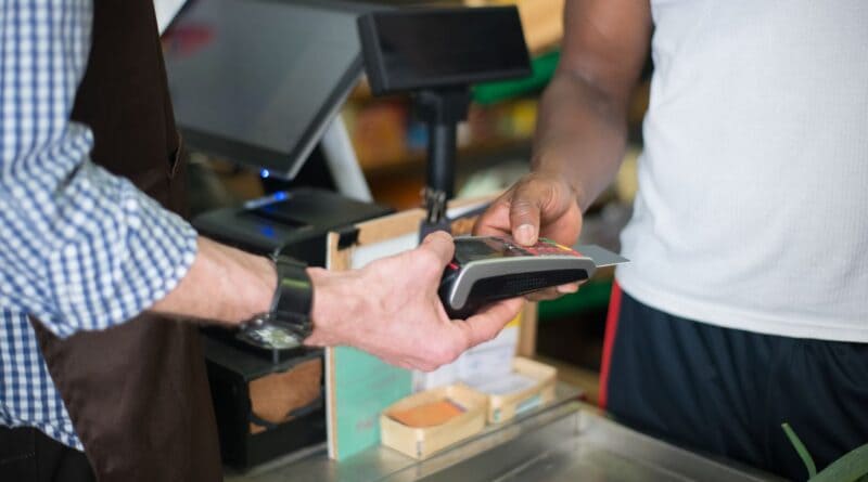 Shopper paying with a card at a store checkout, illustrating Corinth sales tax growth