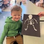Corinth STEM Camp Draws 75 Students for Fall Science Fun Young student holding a paper skeleton craft at the Corinth STEM camp