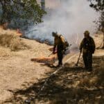 Highway 30 Fires Burn Near Paden in Tishomingo County Firefighters working a grass fire in a dry field, illustrating the Highway 30 fires in Tishomingo County