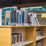 Iuka Public Library Hours Cut in Half; Supervisors Weigh In Books and DVDs on public library shelves, illustrating Iuka Public Library hours cut
