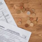 Prentiss County Budget Keeps Tax Rate Flat at 65.7 Mills Tax forms and coins on a table illustrating the Prentiss County tax rate