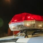 Prentiss County Deputies Seek Suspect in Shed Burglary Police car lights at night, illustrating the Prentiss County burglary suspect search