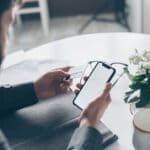 Prentiss County Sheriff Warns of Utility Bill Scam Calls Person holding a credit card and smartphone, illustrating a utility bill scam payment demand
