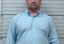 State Auditor announces arrests in Guntown fraud case A man stands in front of a height chart in a booking-style photo.